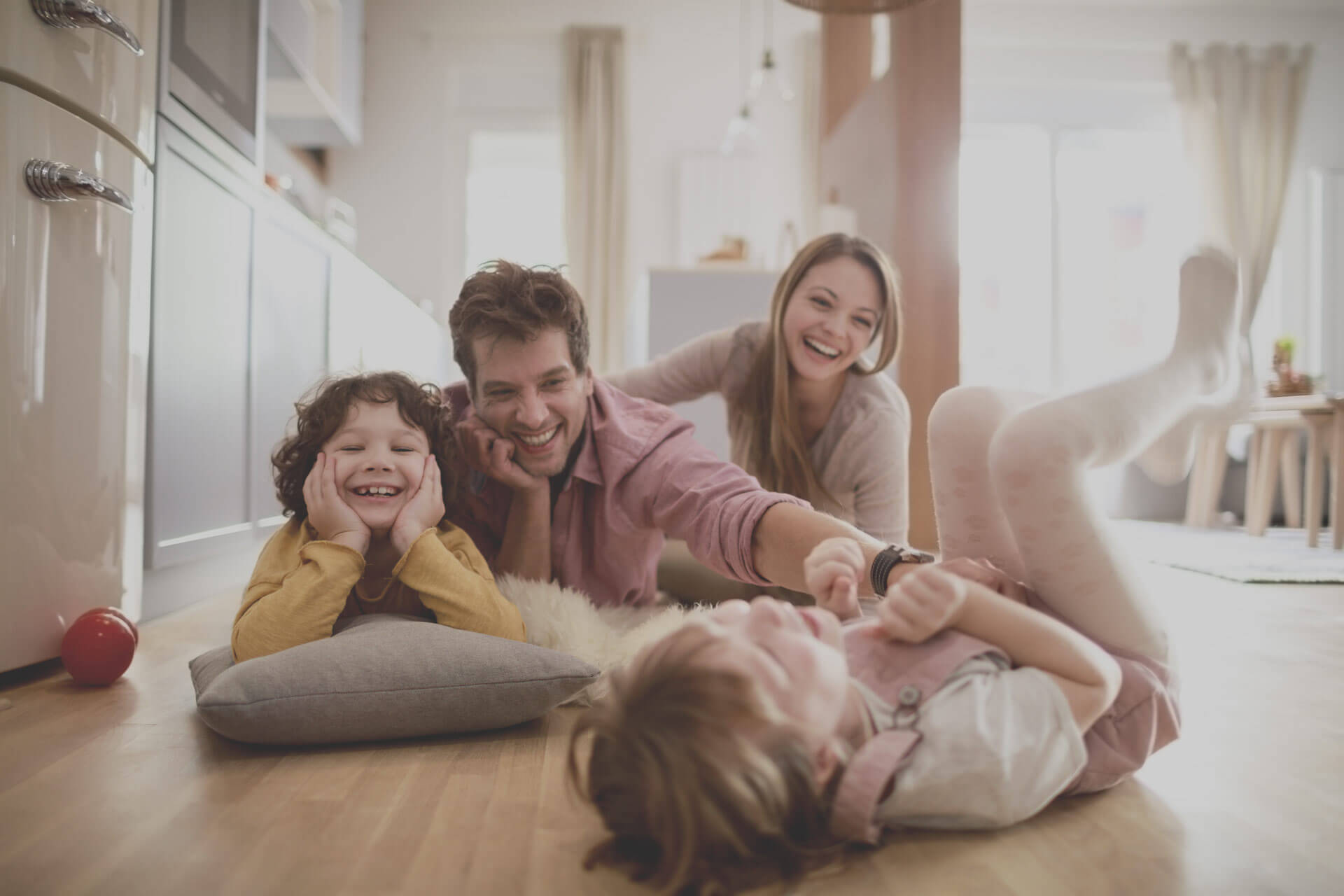 Family playing on the kitchen floor